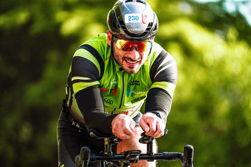 Free A focused cyclist riding through a sunlit path, showcasing an active and healthy lifestyle. Stock Photo