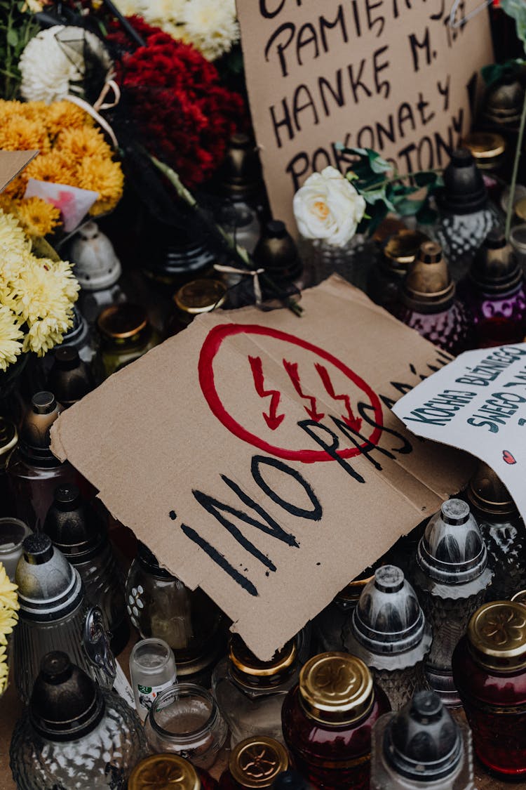 Pro Choice Posters Among Graveyard Candles And Flowers 