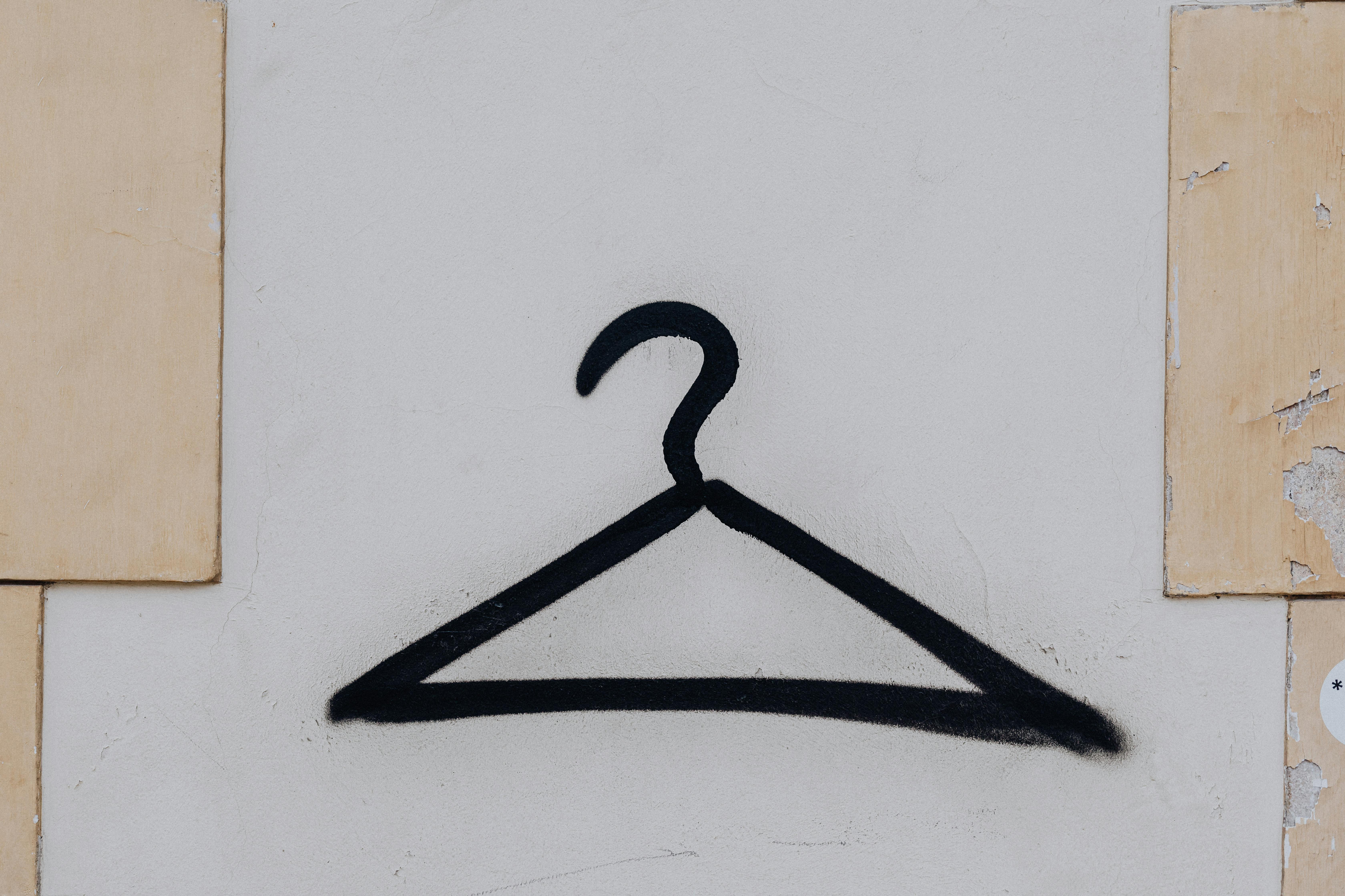 black coathanger graffiti on wall