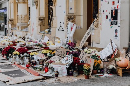 Free A street memorial with flowers, candles, and protest signs highlighting social issues and women's rights. Stock Photo