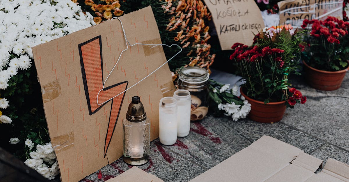 Cardboard signs, flowers, and candles at a protest scene advocating for women's rights.