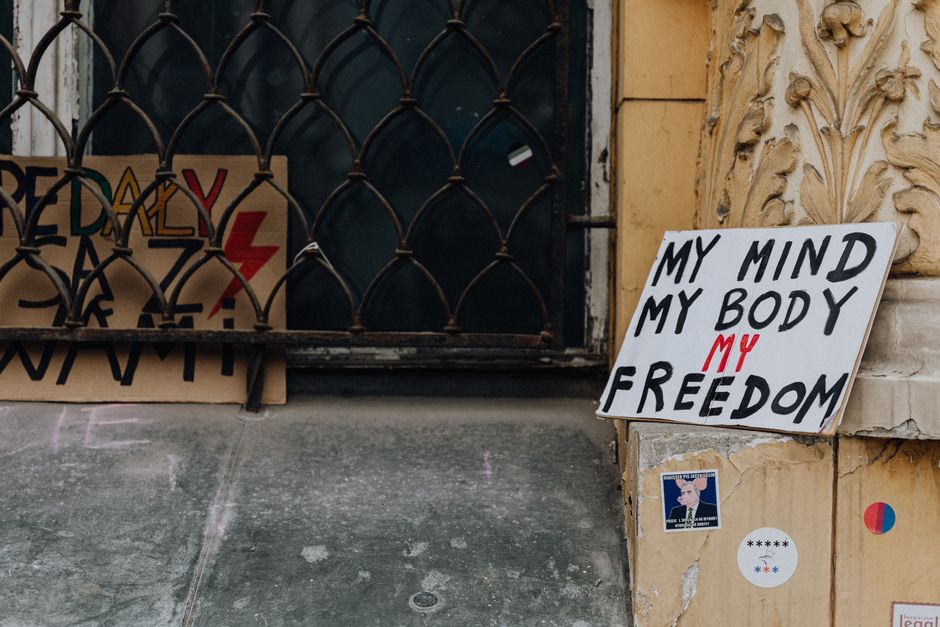 Carteles de protesta que abogan por la libertad y la elección colocados frente a la fachada de un edificio histórico.