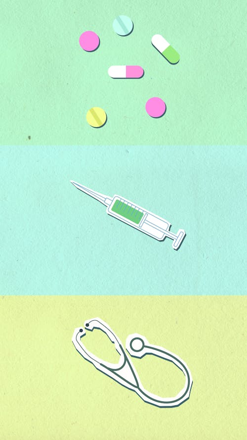 Free Overhead view of cutout paper appliques representing stethoscope near syringe and capsules with pills on colorful background Stock Photo