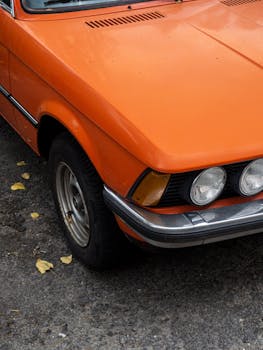 Detailed shot of the front section of a vintage orange car parked in Berlin.
