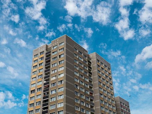 Free Low-angle shot of a modern apartment in Berlin, framed by a vibrant blue sky with scattered clouds. Stock Photo