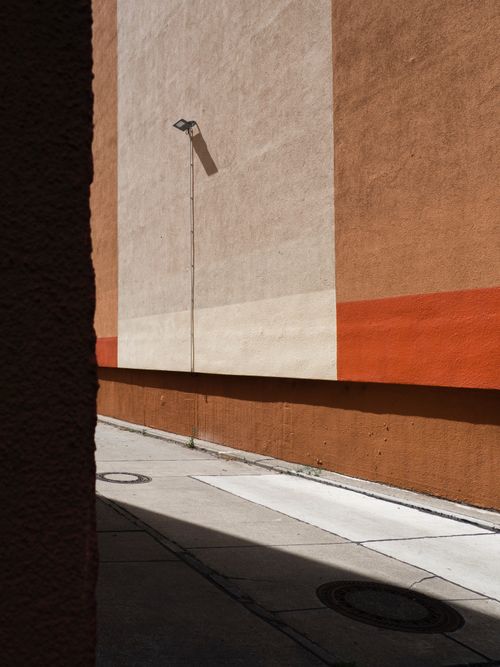 Free A sunlit alleyway in Berlin, showcasing concrete walls and modern urban architecture. Stock Photo