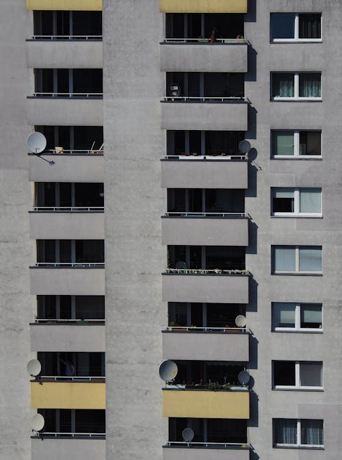 A Building With Satellite Dishes on Balconies 