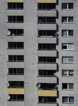 High-rise apartment building in Berlin with balconies and satellite dishes.