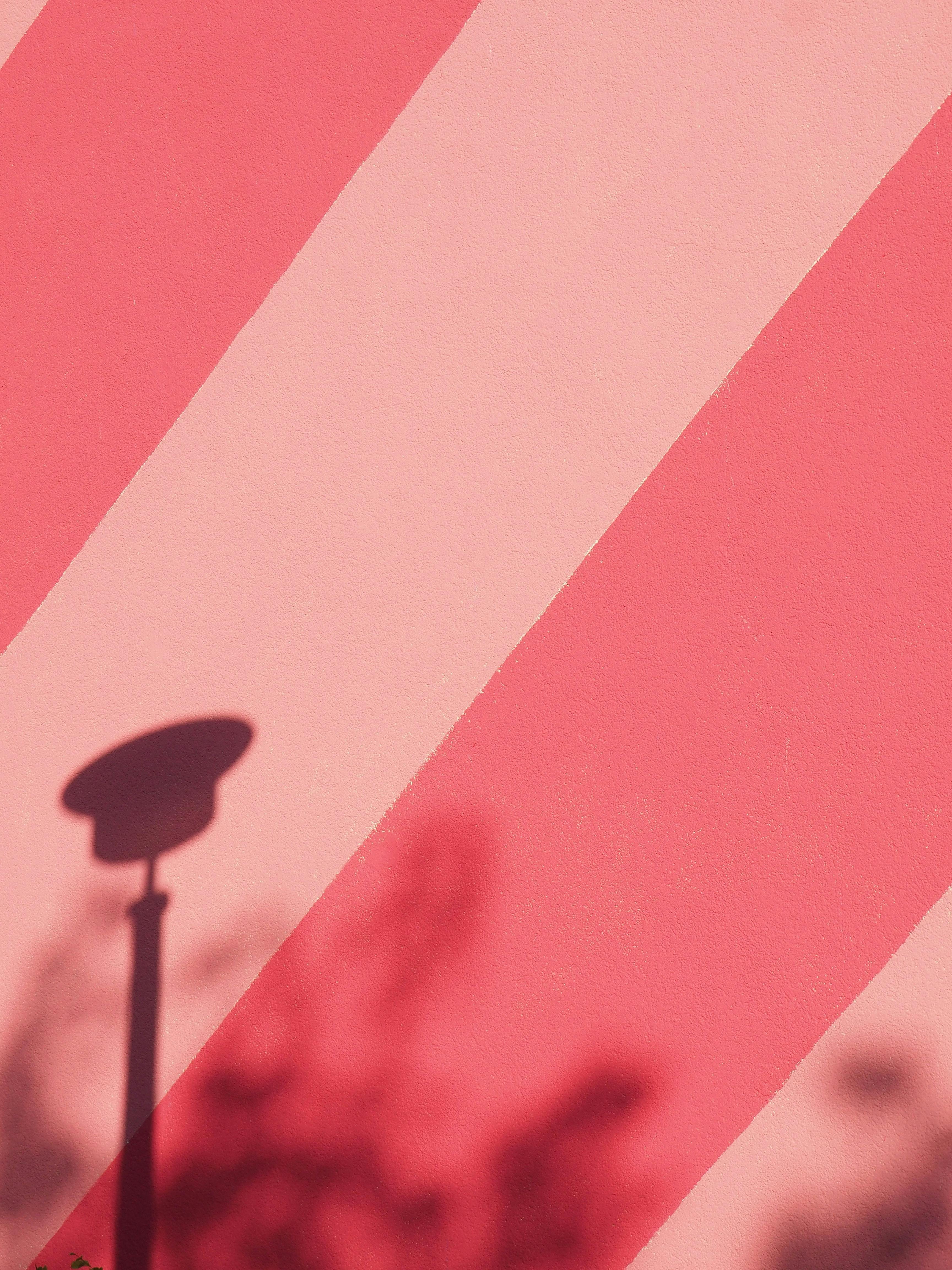 Abstract patterns with pink hue and shadow play on a Berlin wall. Urban design elements.