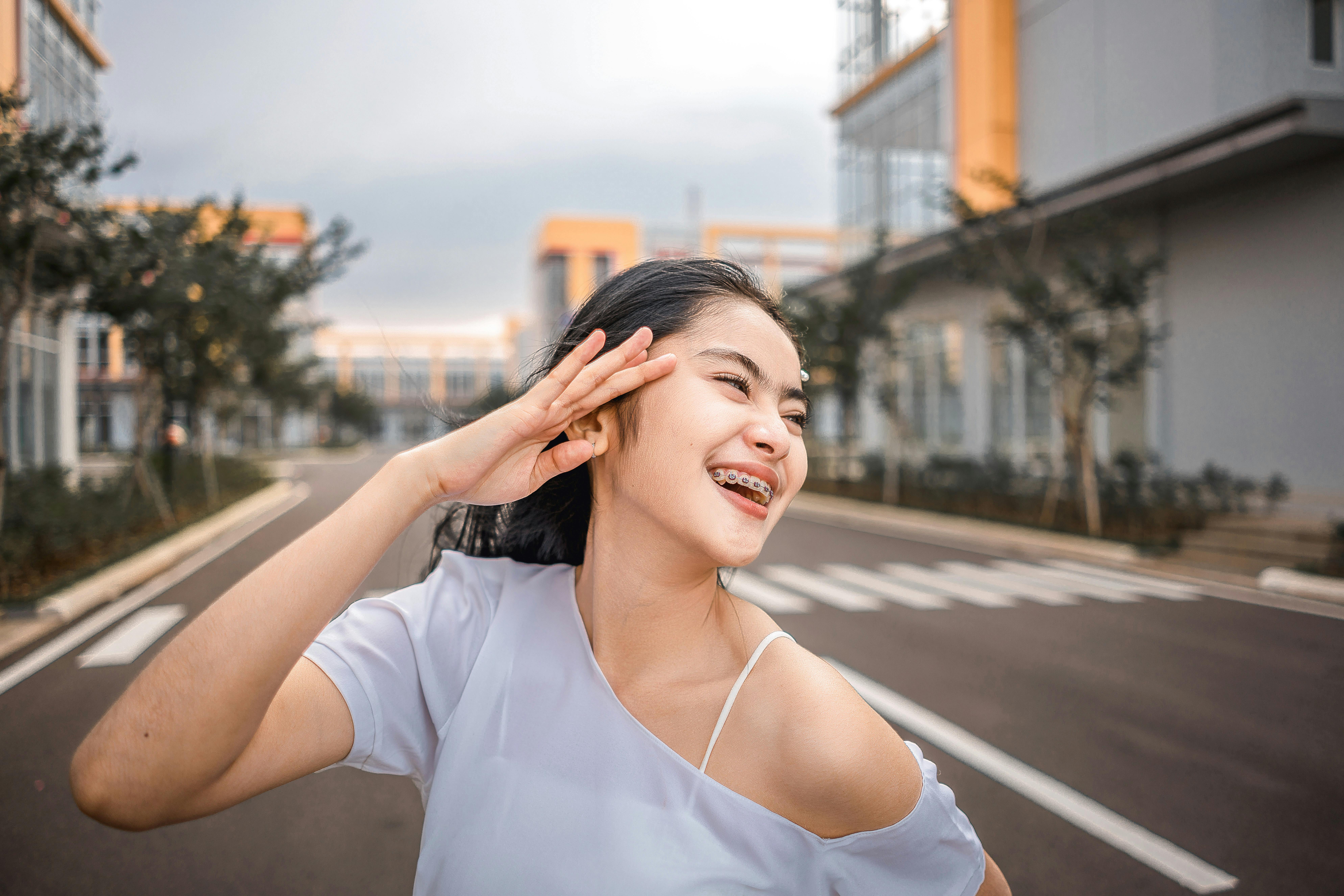 白天，戴着牙套的幸福女人在城市街道上微笑