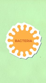 Top view of decorative cardboard applique of orange virus with Bacteria title on green background
