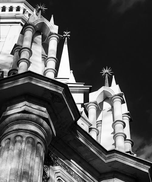 Free From below black and white of facade details of historic Tsaritsyno Palace with columns and spires on sunny day Stock Photo