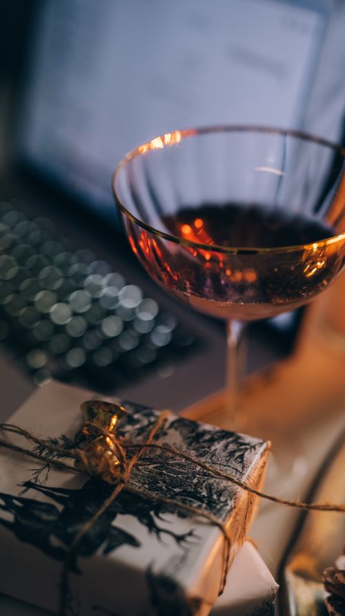Free Close-up of a wine glass and rustic gift box, perfect for celebrations. Stock Photo