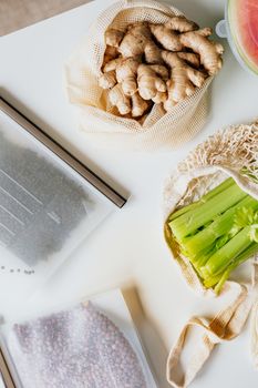 白色平面上展示着新鲜的姜根、芹菜和豆类的图像