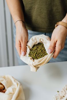 手里拿着一袋绿豆，凸显可持续的食物储存方式