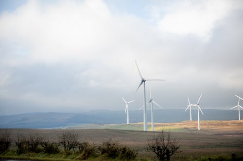 White Wind Turbines Under Cloudy Sky