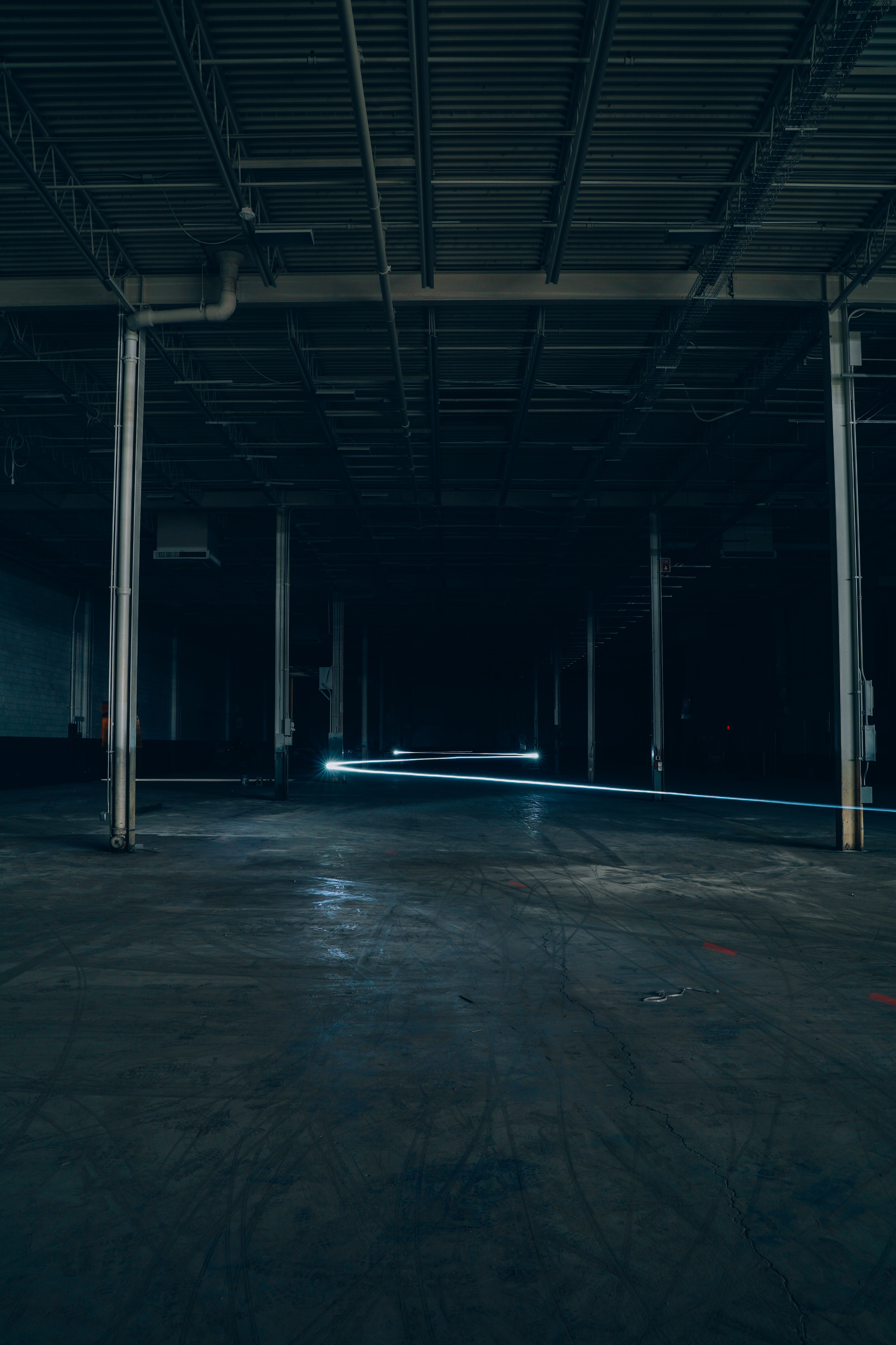 An empty warehouse with steel columns and a bare concrete floor