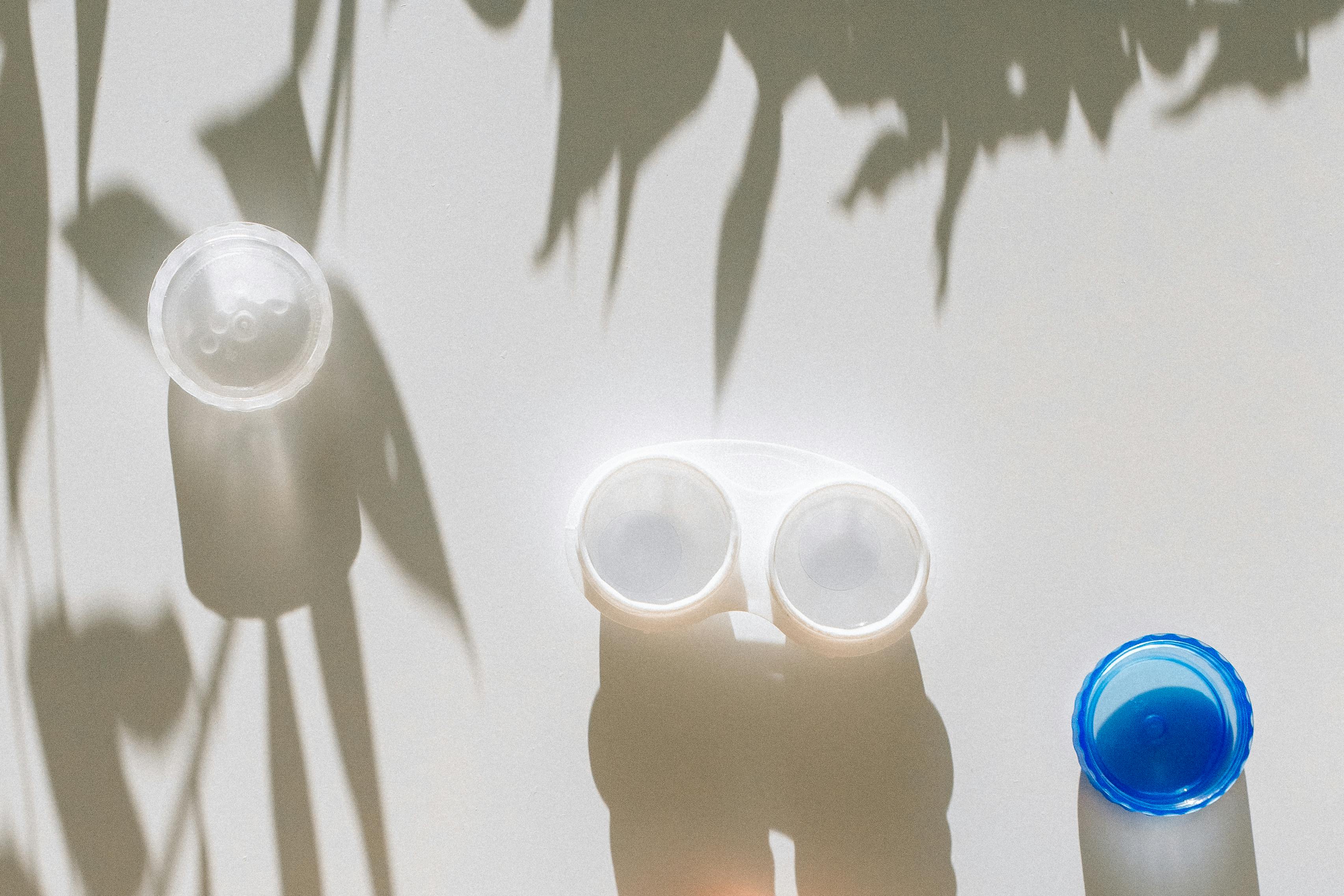 白色桌子上的隐形眼镜盒顶视图，阴影游戏营造出简约与洁净感