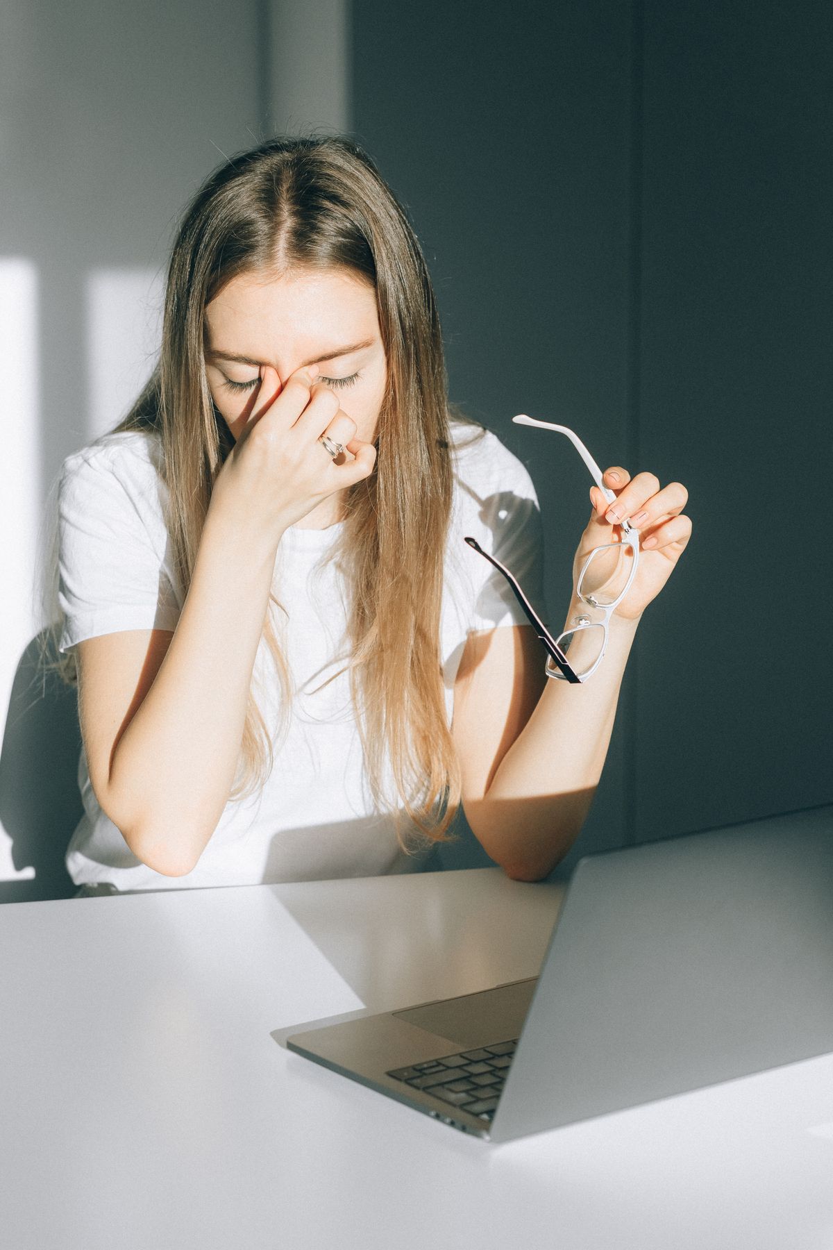 Young woman holding glasses with digital eye strain