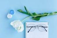 White Rose Beside Blue and Silver Scissors