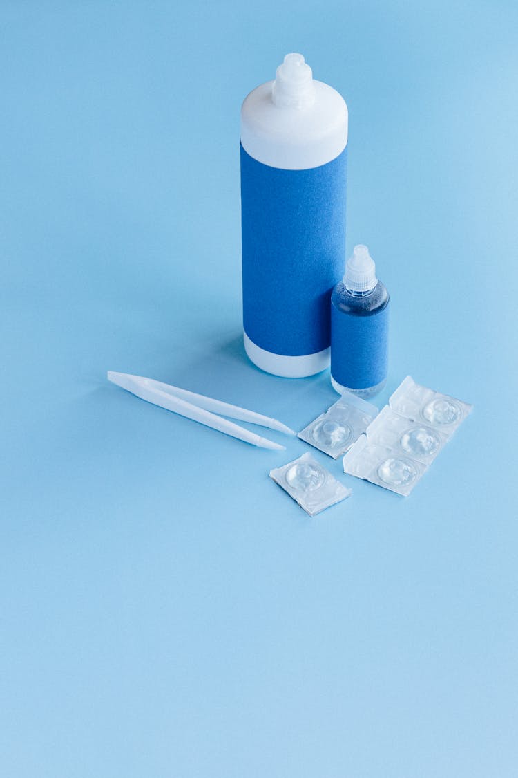 Close-Up Shot Of Plastic Bottles Beside Tweezers