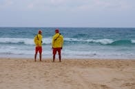 2 Men in Yellow Shirt Standing on Beach
