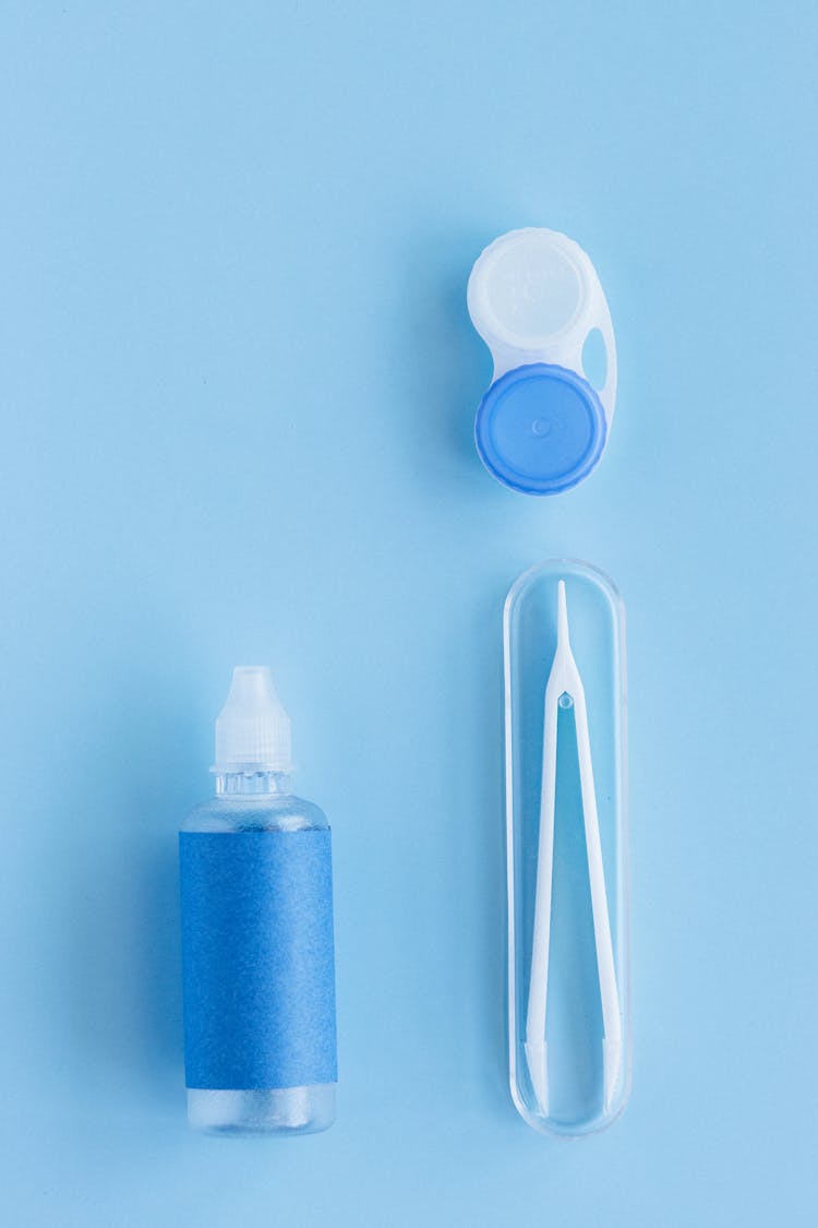 Close-Up Shot Of A Plastic Bottle Beside Tweezers