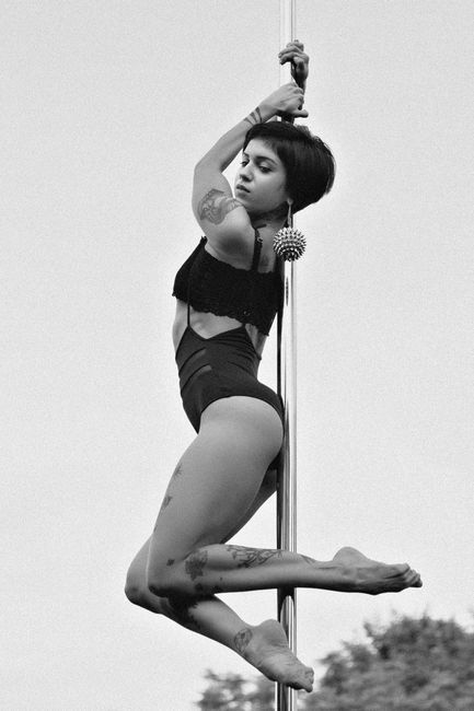 Graceful pole dancer captured in artistic black and white photography.