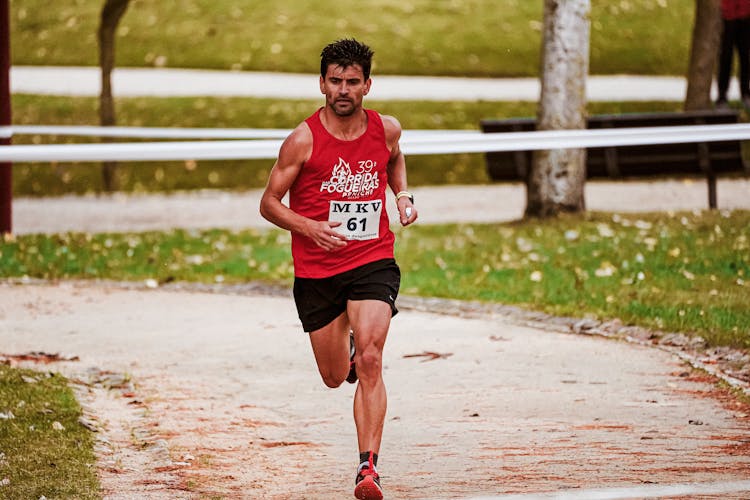 Man In Red Tank Top Running On Path