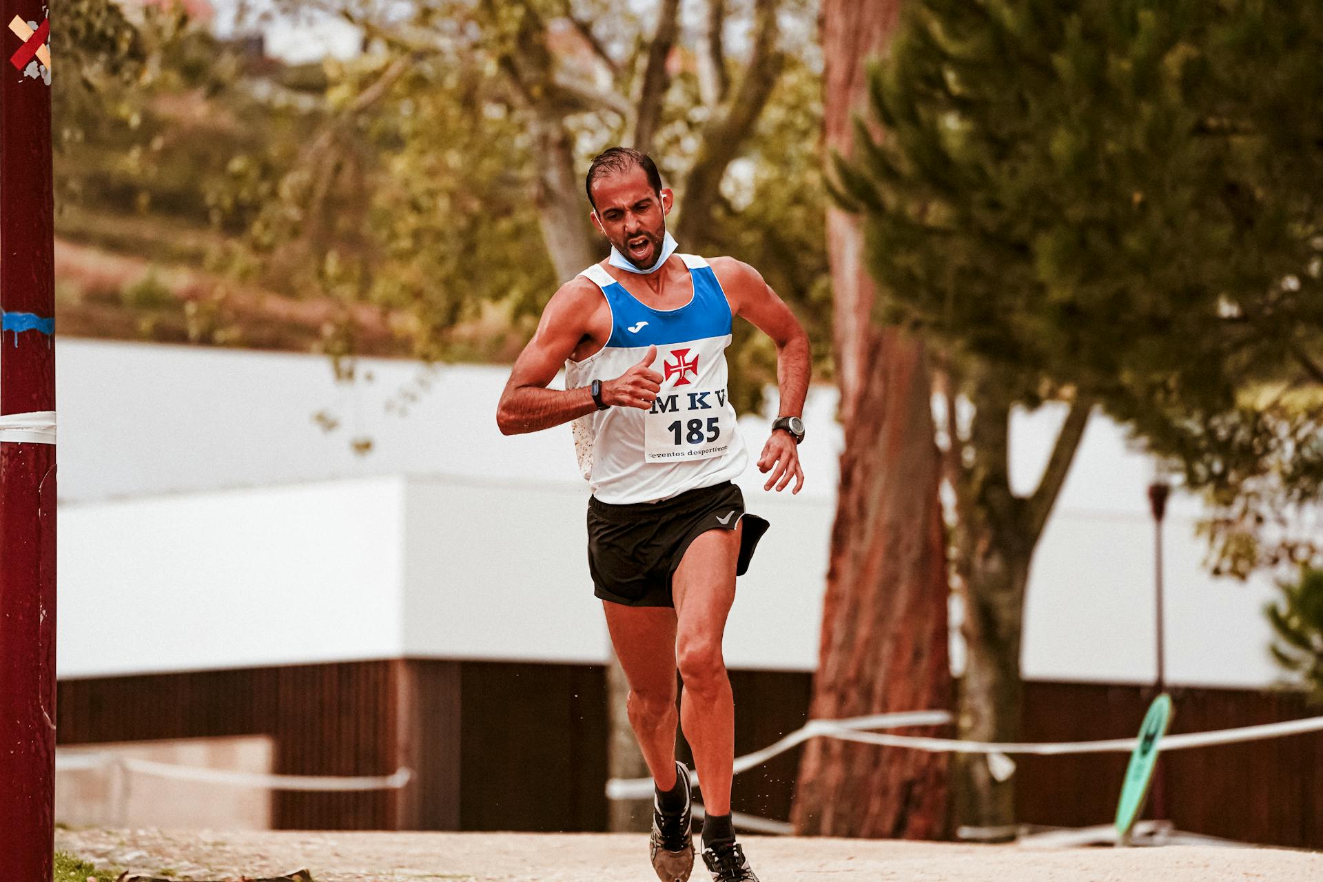 Determined marathon runner in action on a sunny day, showcasing endurance and athleticism.