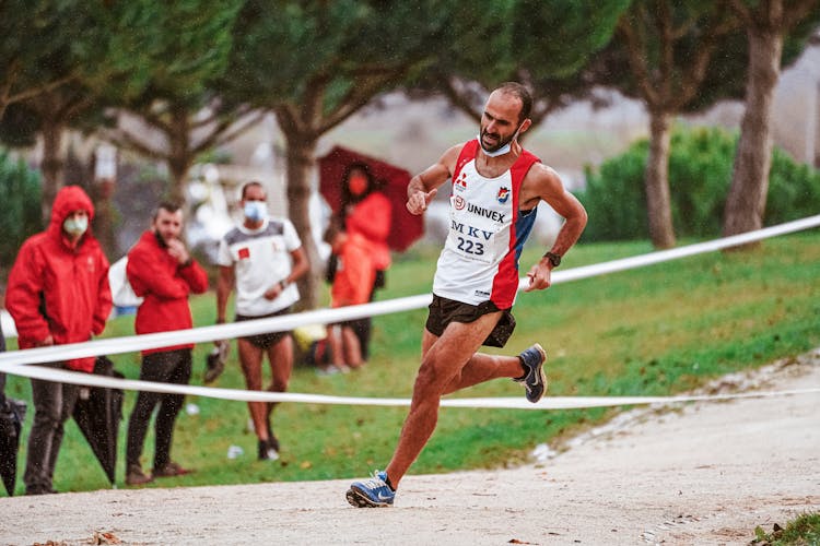 Man In Sportswear Running On Track Field