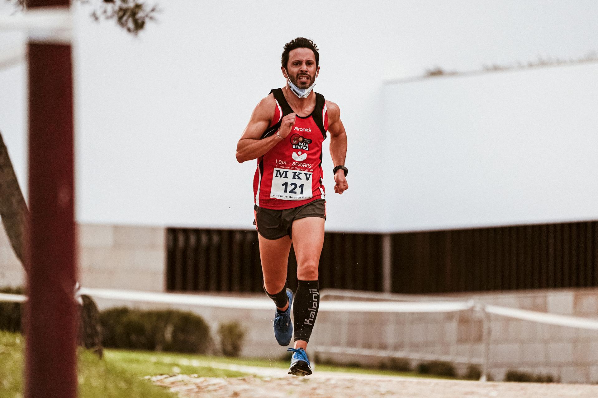 Focused male runner participating in an outdoor running race, wearing sportswear.