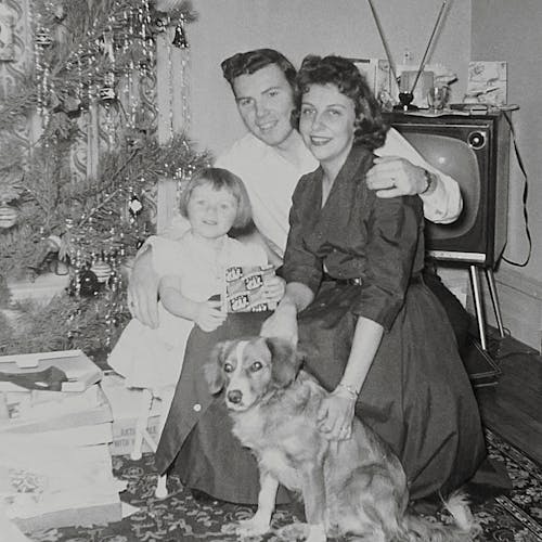Grayscale Photo of Family And Pet Posing Near A Christmas Tree 