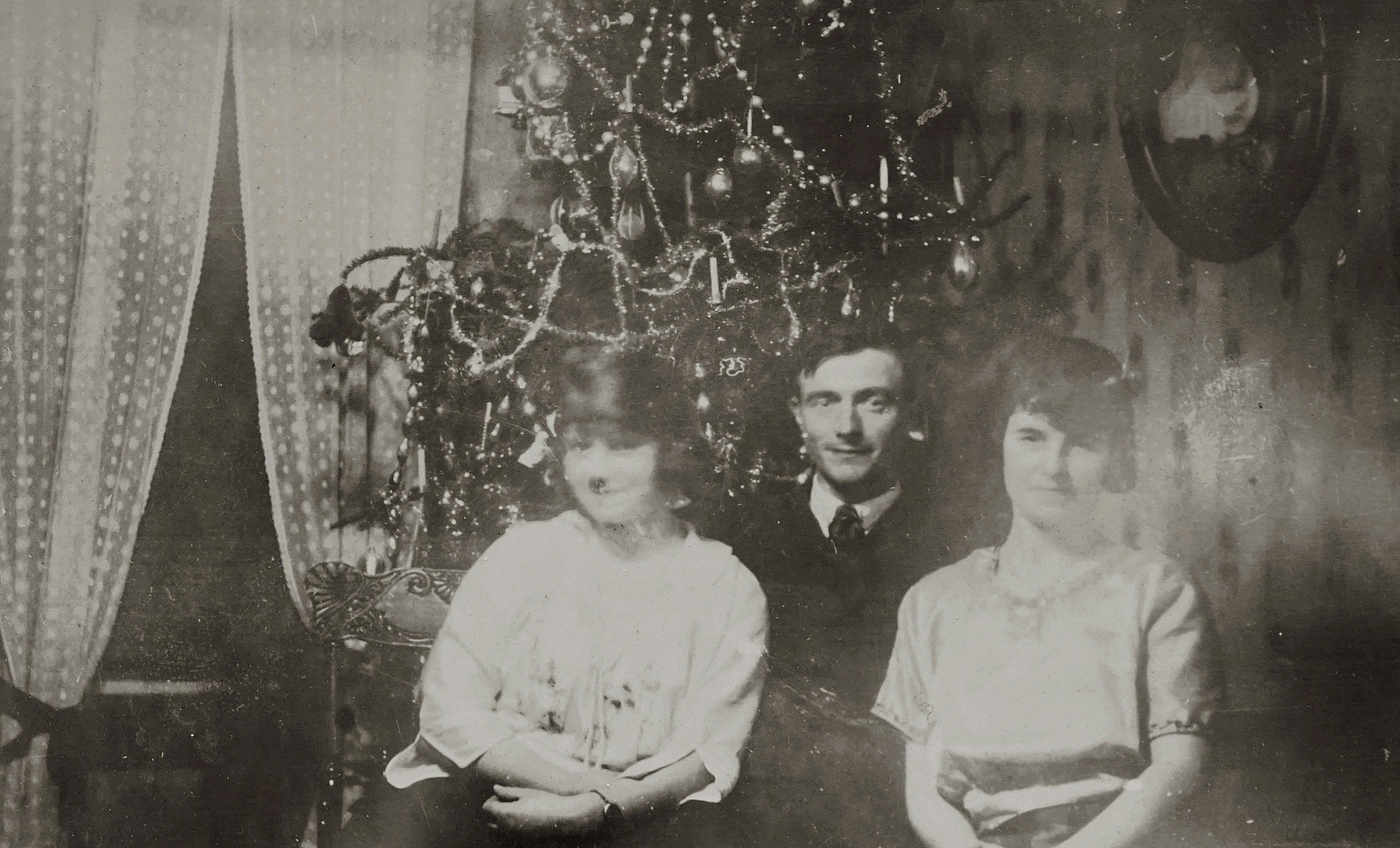 A classic vintage family portrait beside a decorated Christmas tree.