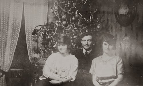 Father And Daughters Posing Near A Christmas Tree