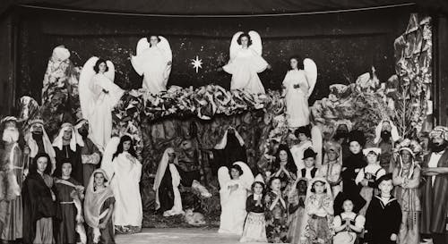 Grayscale Photo of Children Wearing Costumes At A Christmas Presentation