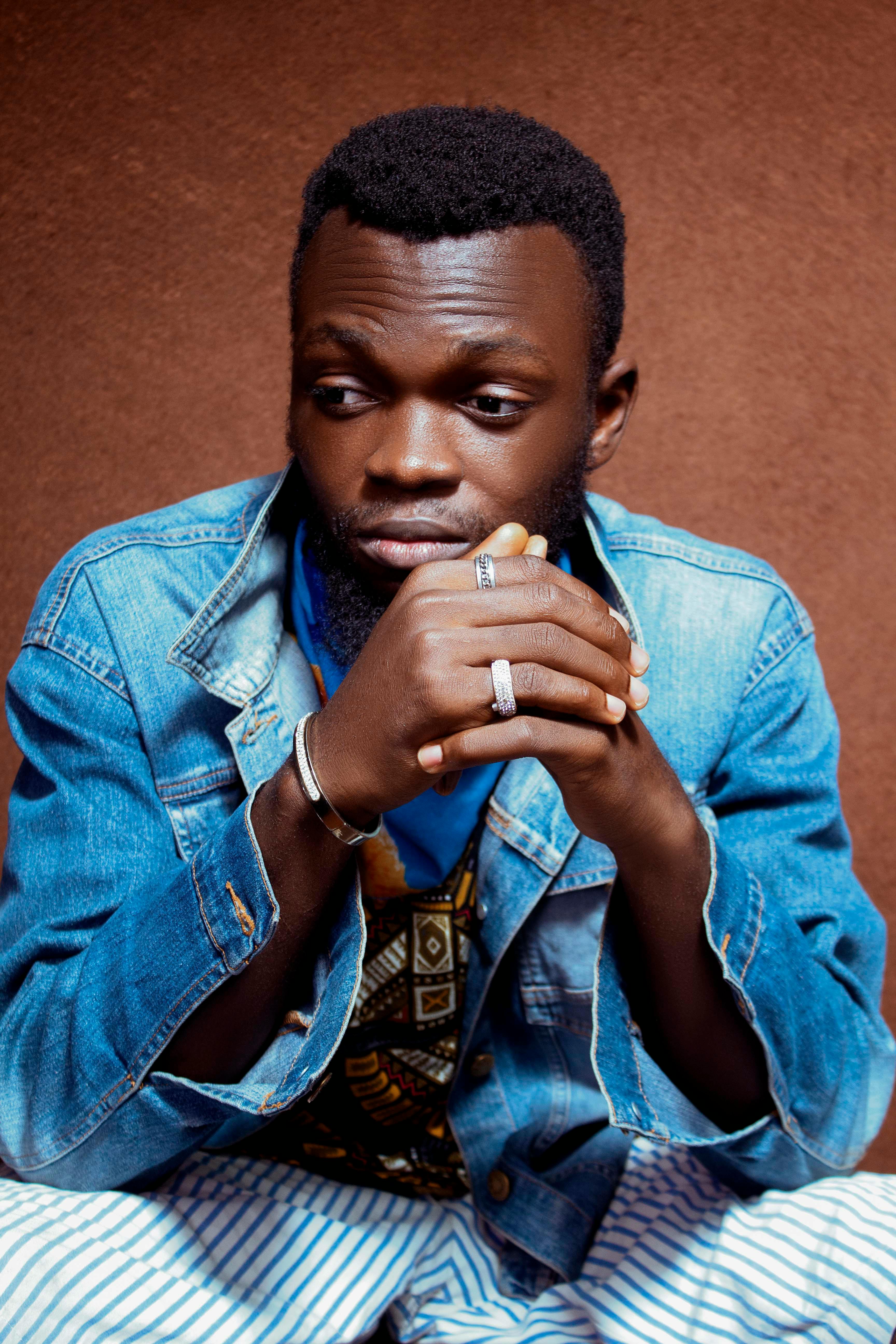 Studio portrait of a contemplative man in a denim jacket showcasing style and flair.