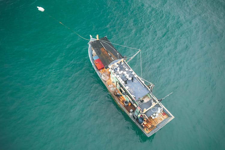 Aerial View Of Fishing Boat Floating On Azure Seawater