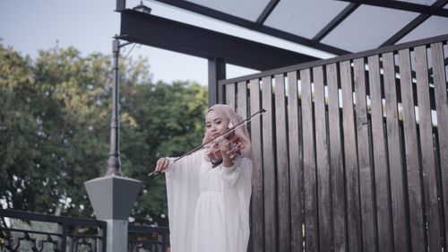 Free Elegant woman in hijab plays violin outdoors, showcasing classical music and cultural beauty. Stock Photo