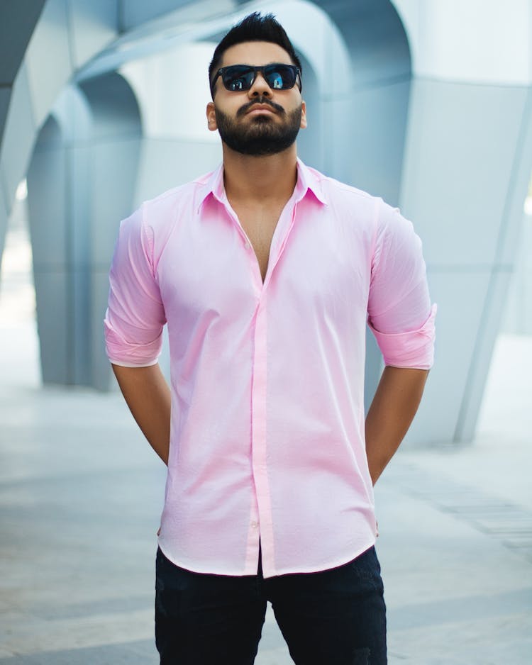 Man In Pink Polo Shirt And Black Pants Wearing Black Sunglasses