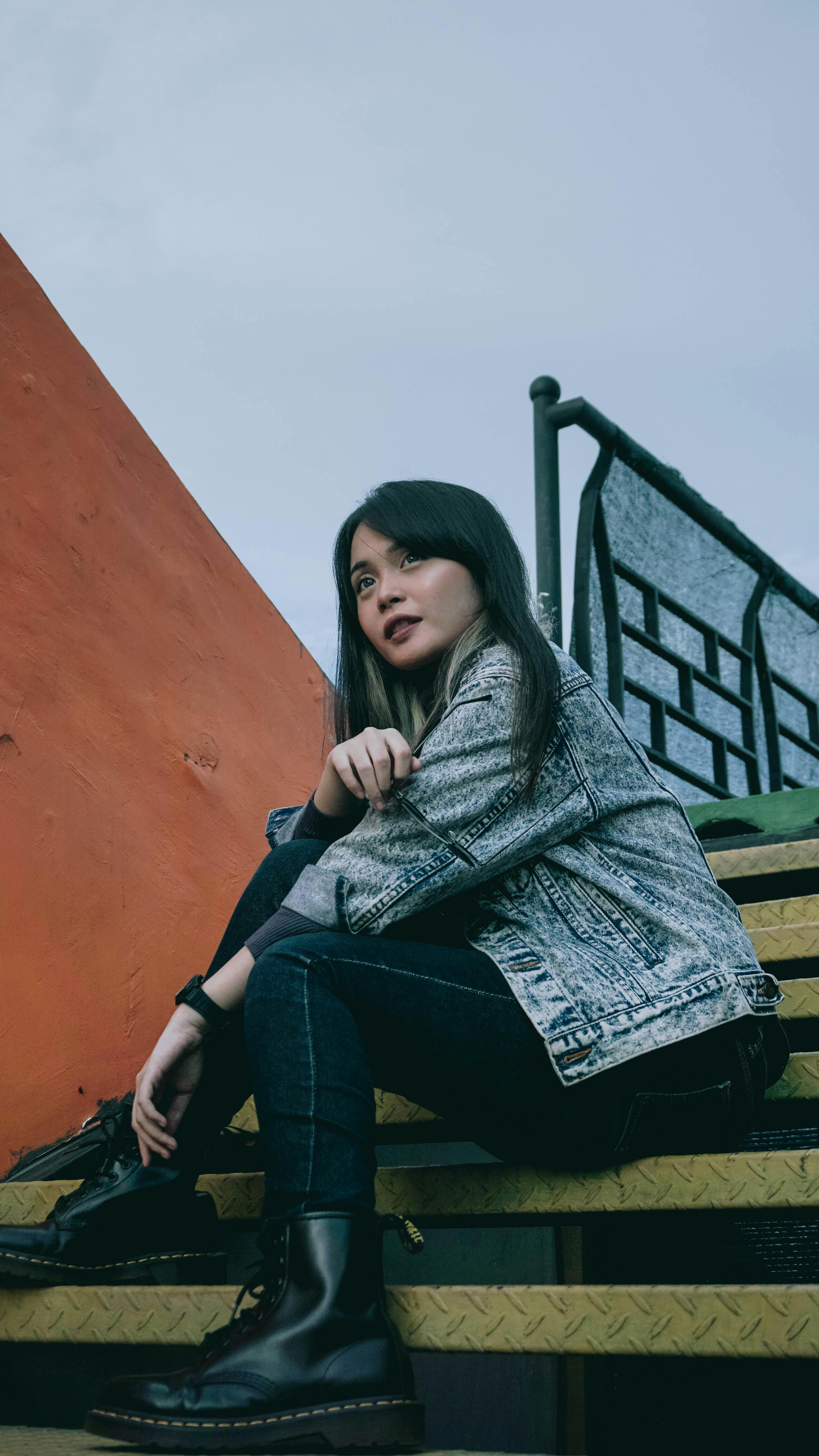 Woman in Black Leather Jacket and Blue Denim Jeans Sitting on Floor ...