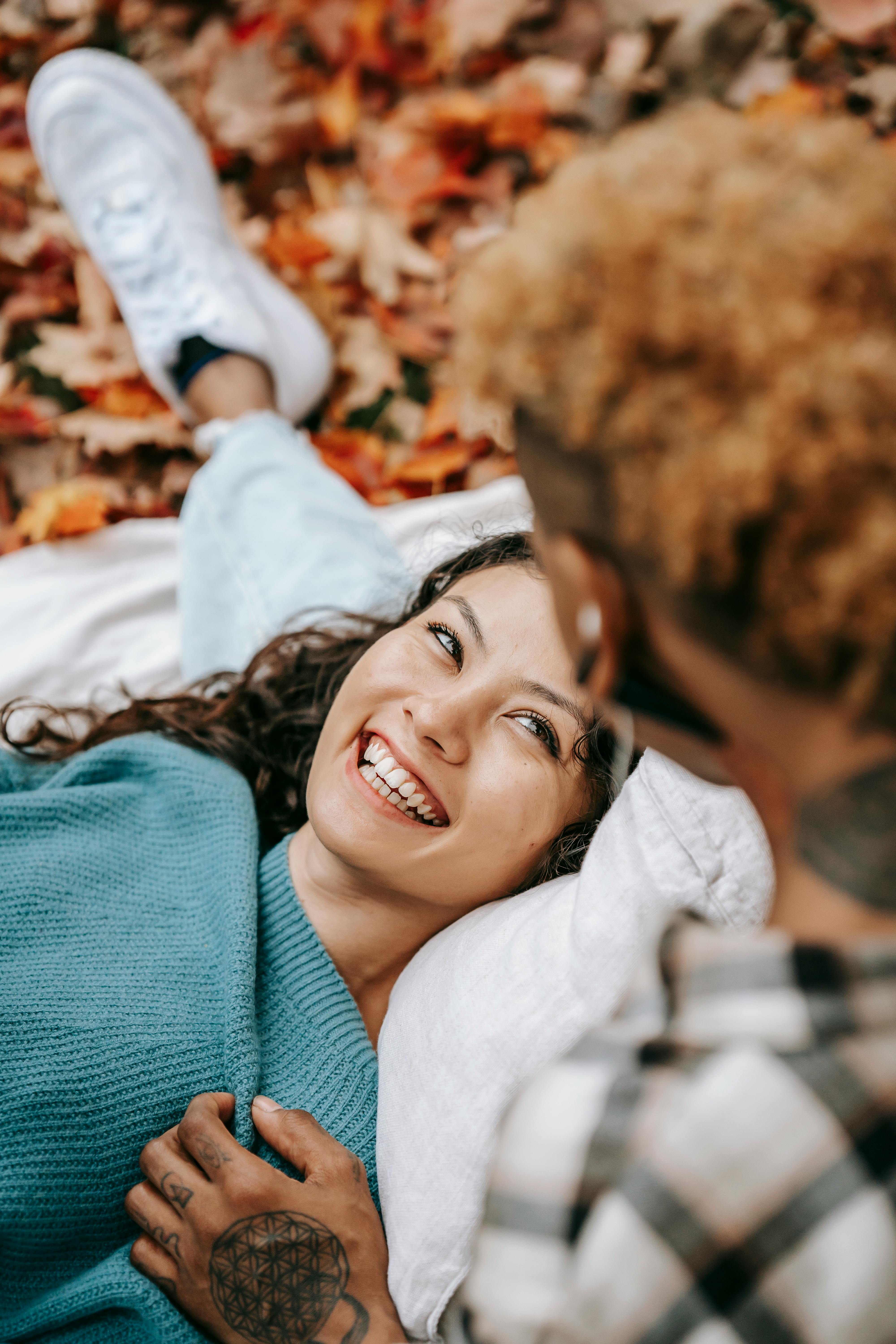 laughing hispanic woman with partner in park