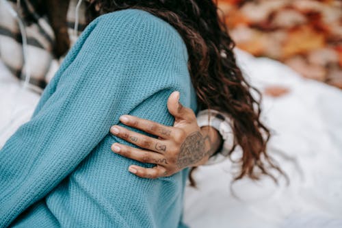 Crop tattooed couple embracing in park