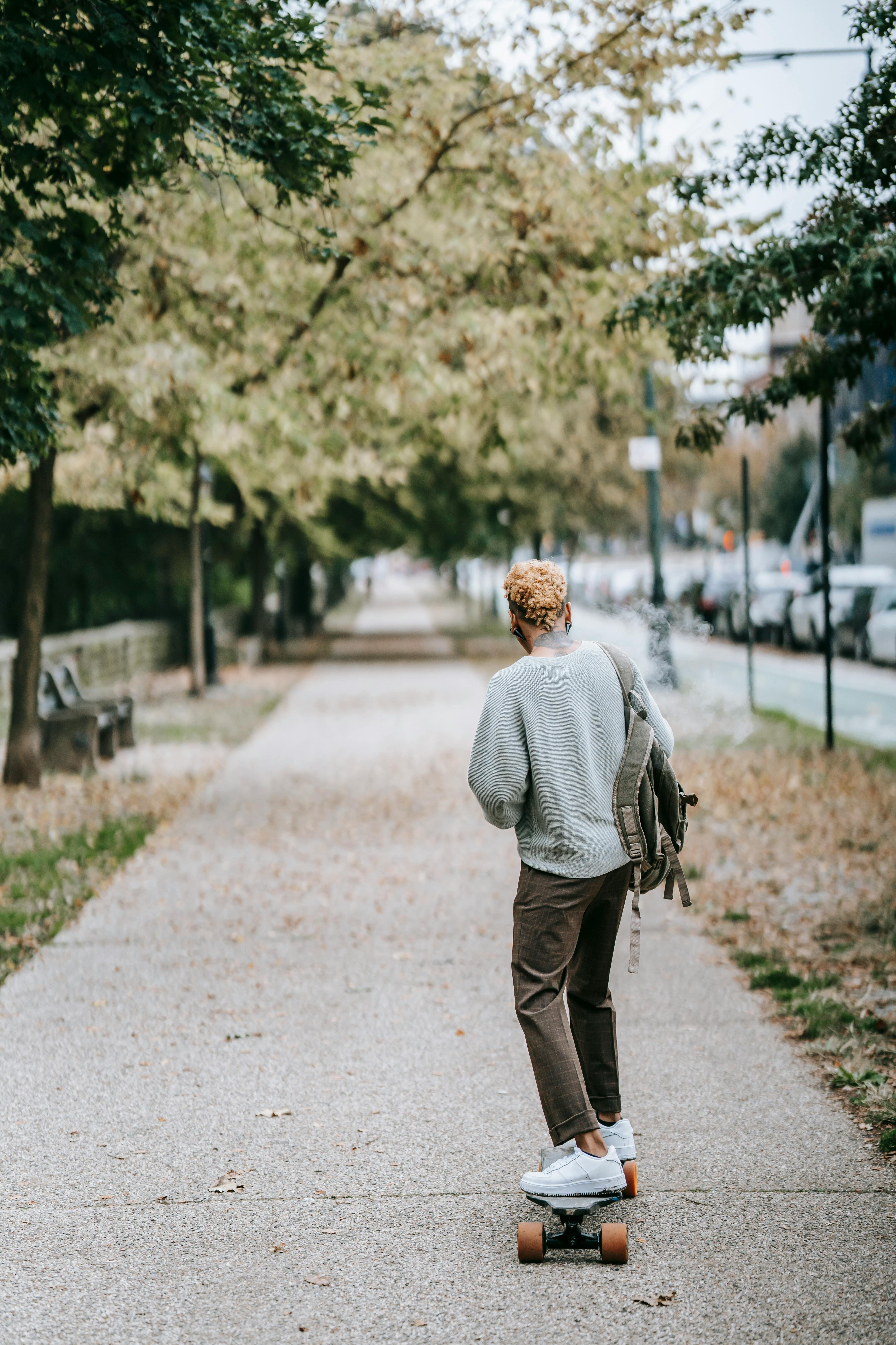 人们在公园绿树成荫的小径上滑板，展现了户外娱乐与休闲
