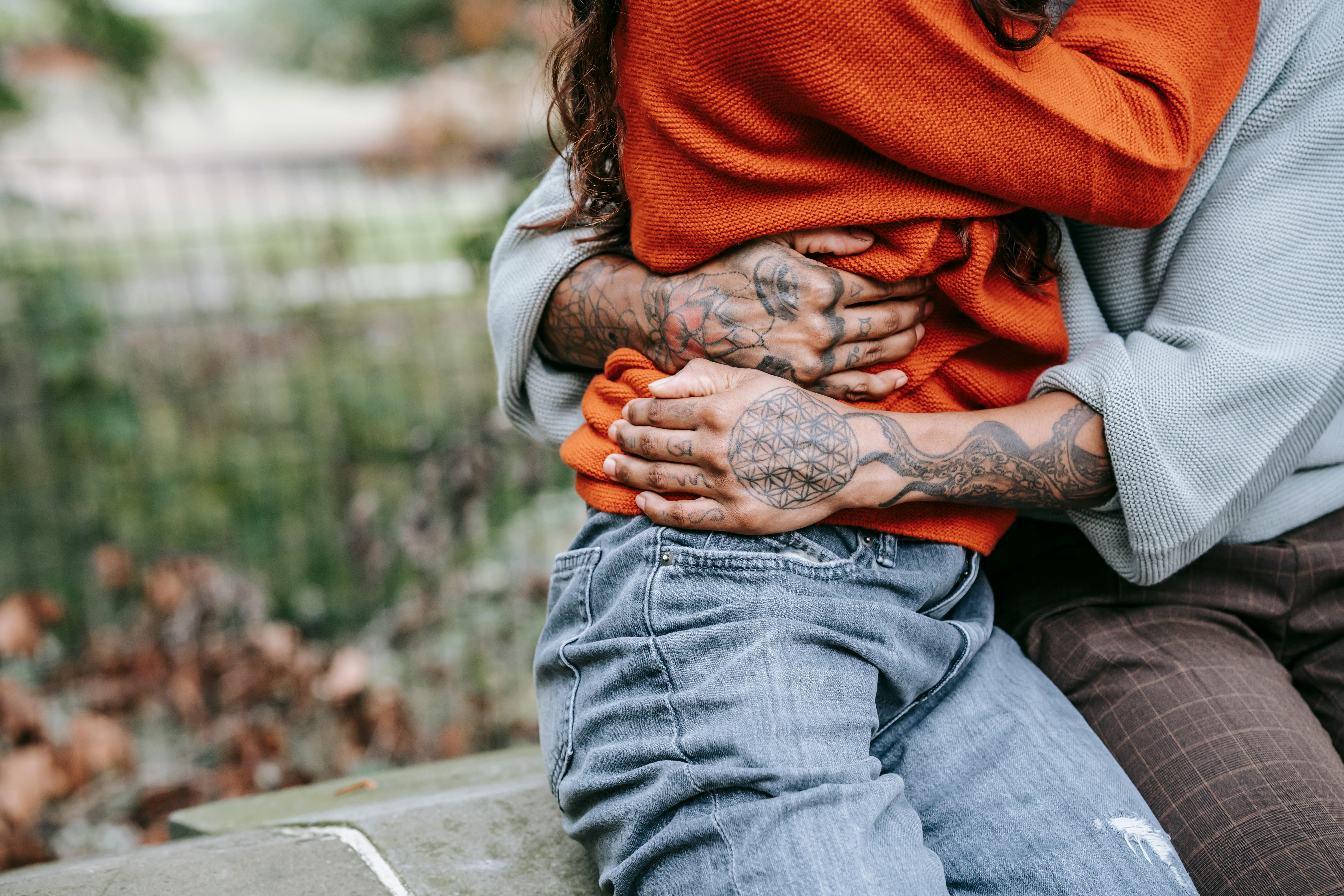 unrecognizable couple hugging each other in park