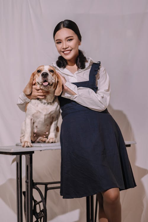 Woman in Blue Dress Hugging Brown and White Short Coated Dog