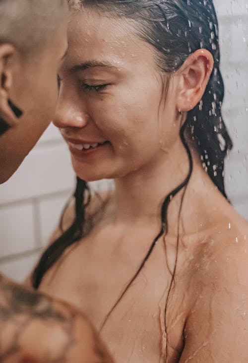Free Multiracial naked couple having shower together Stock Photo