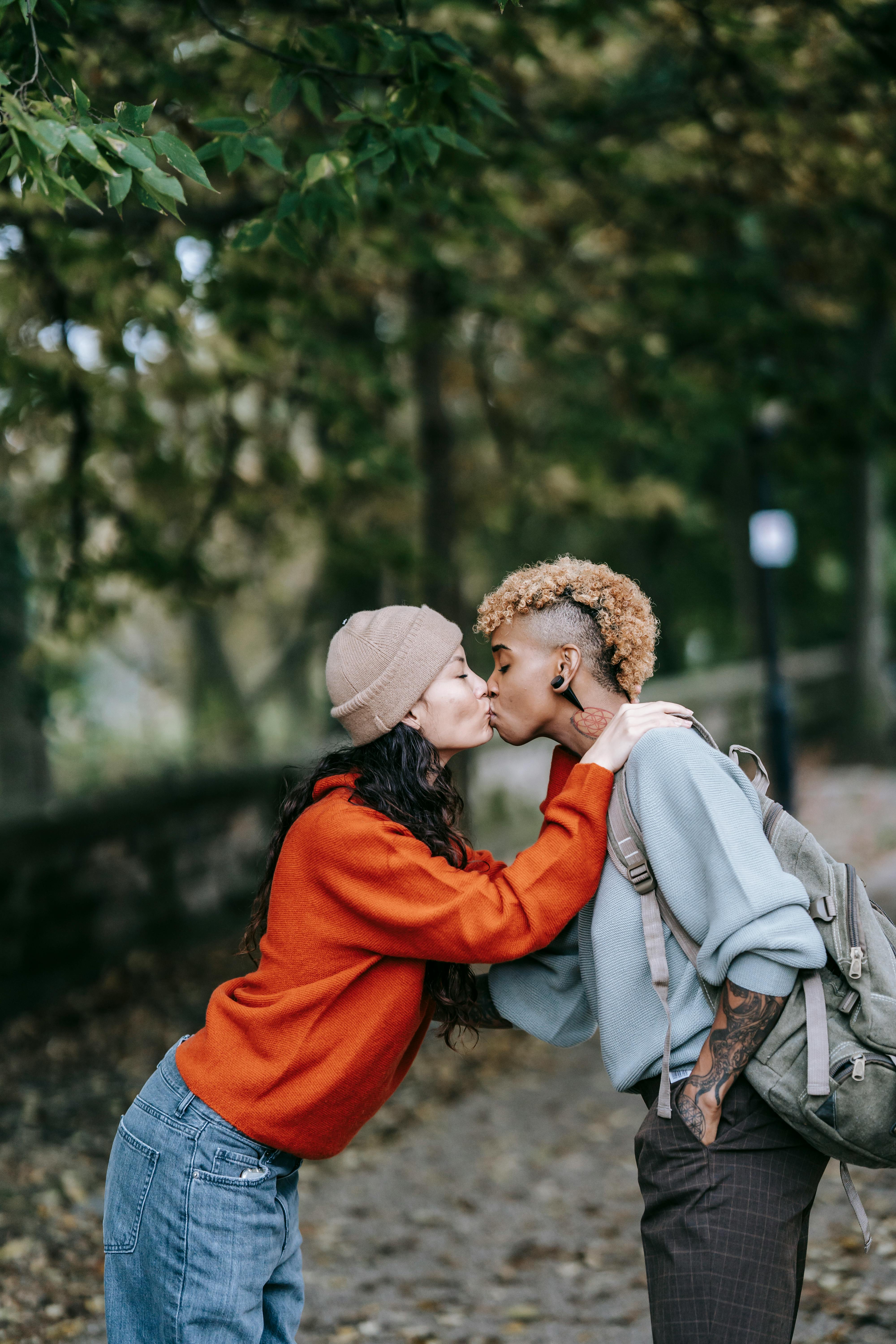 Happy young diverse couple kissing in urban park on autumn day · Free Stock  Photo
