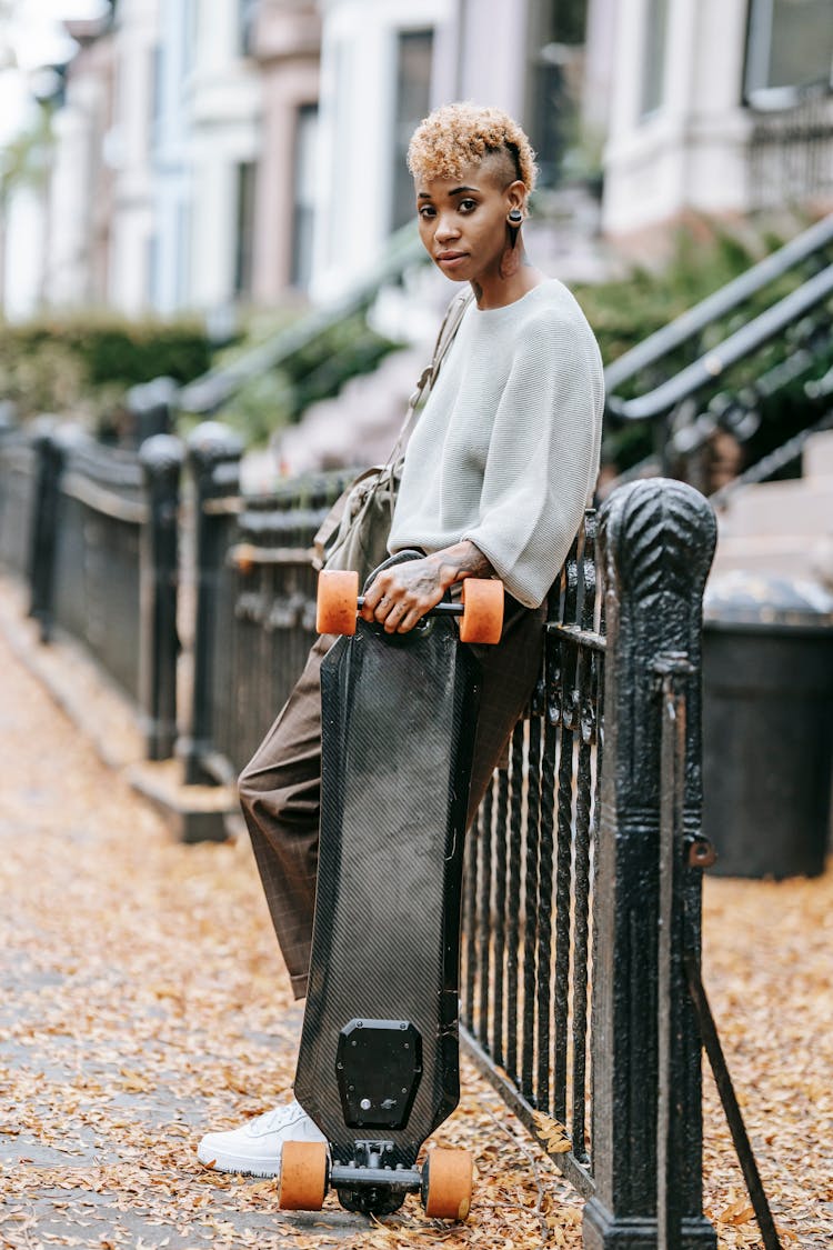 Confident Hipster Black  Woman Standing With Longboard In City Street