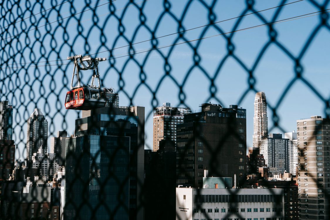 Cable car running over modern city with tall buildings · Free Stock Photo